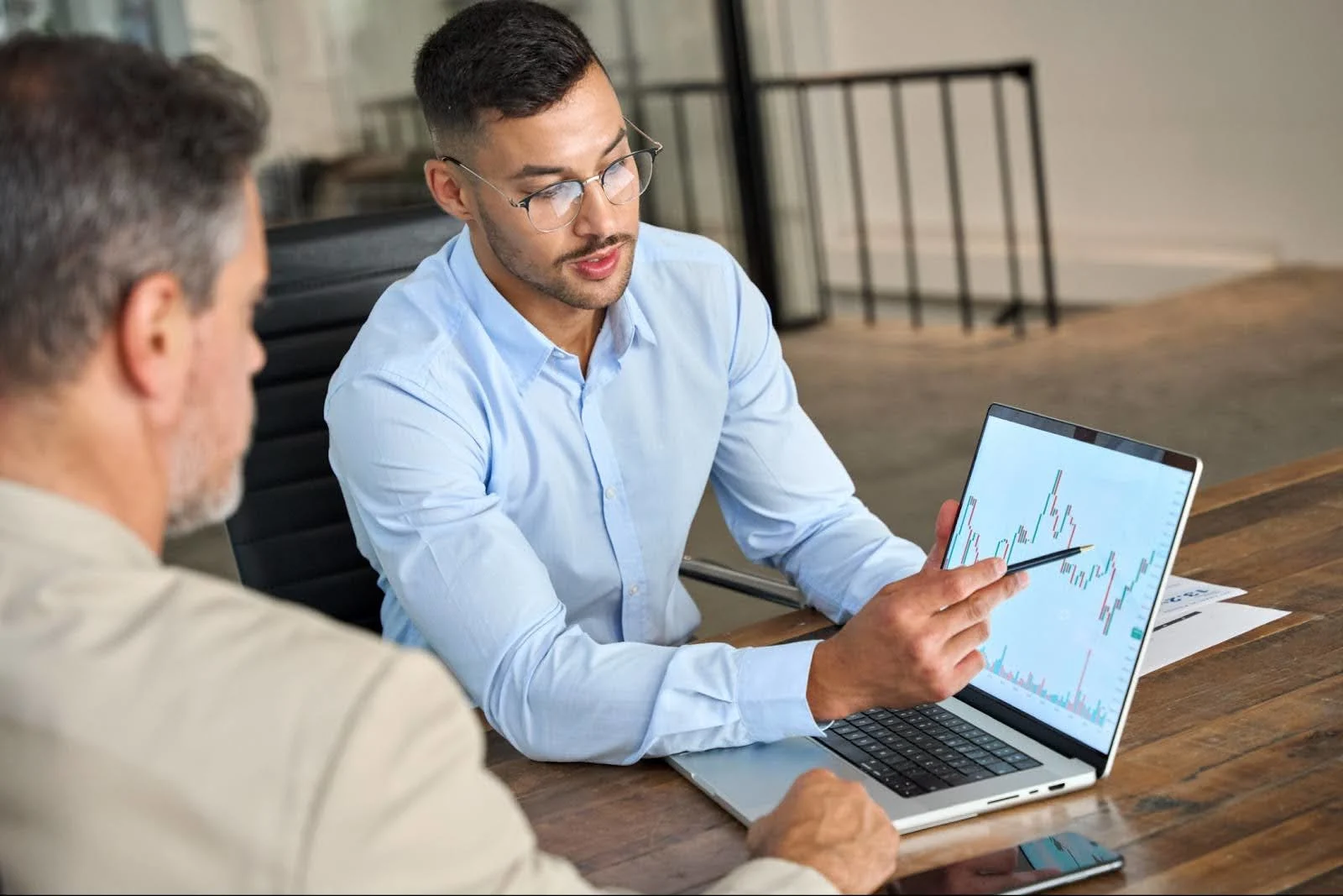 Un collaborateur désigne un graphique sur son ordinateur pour analyser les dépenses carburant de l’entreprise.