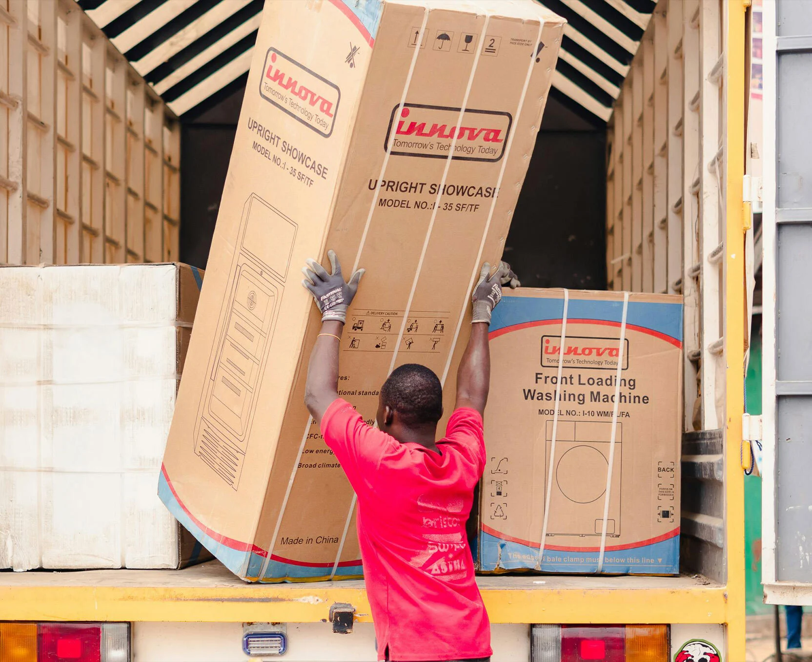 Medewerker laadt grote dozen in een vrachtwagen