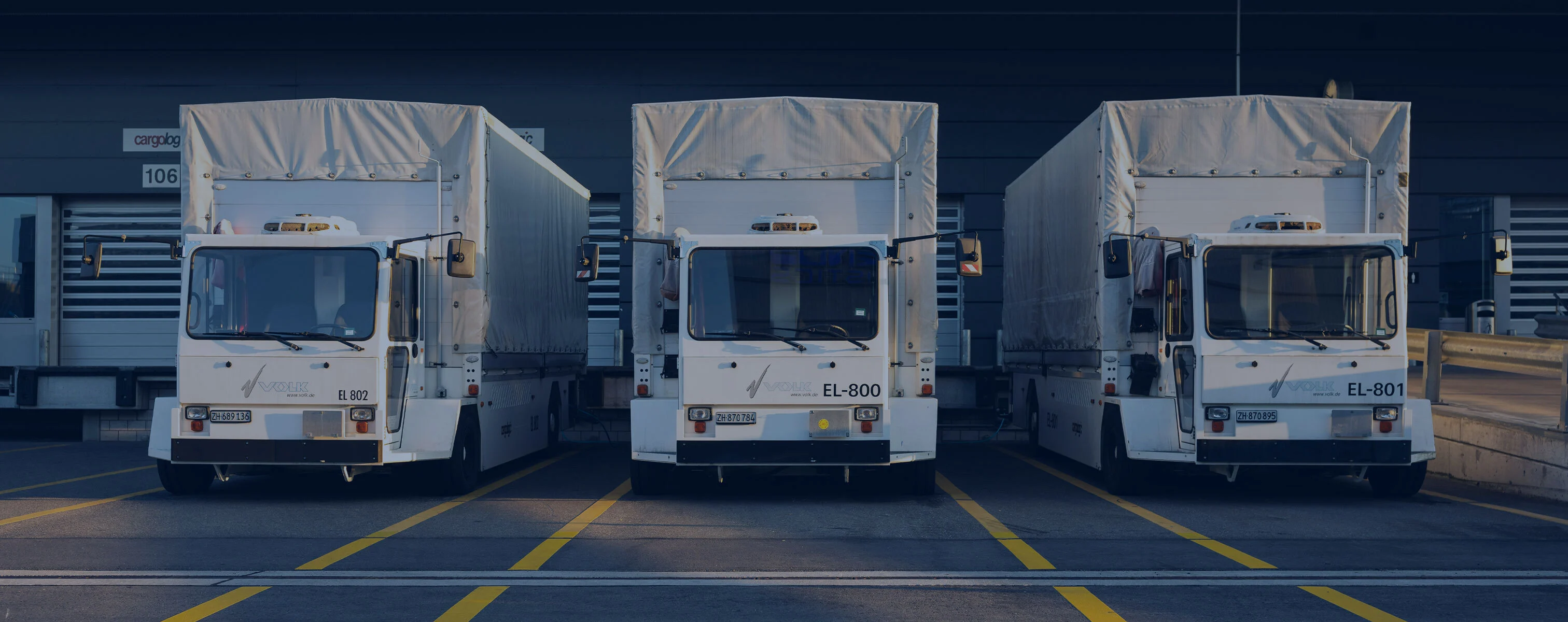 Trois camions garés sur un quai de chargement