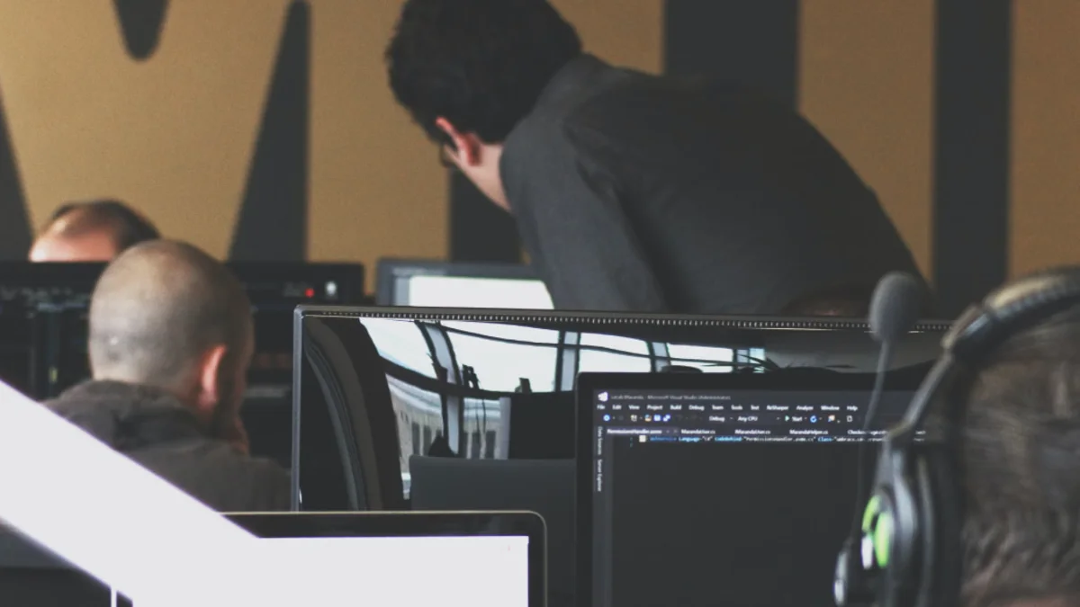 People looking at code on computers