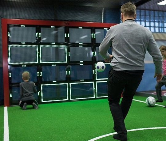 Man playing with his children on the Sutu Interactive ball wall