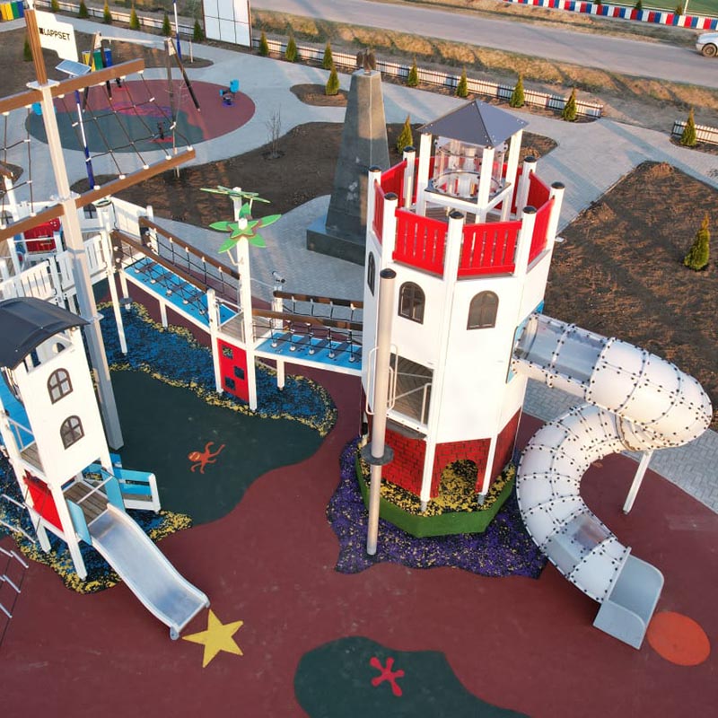 The large tailored playground equipment consists of a ship and a lighthouse, connected by a bridge