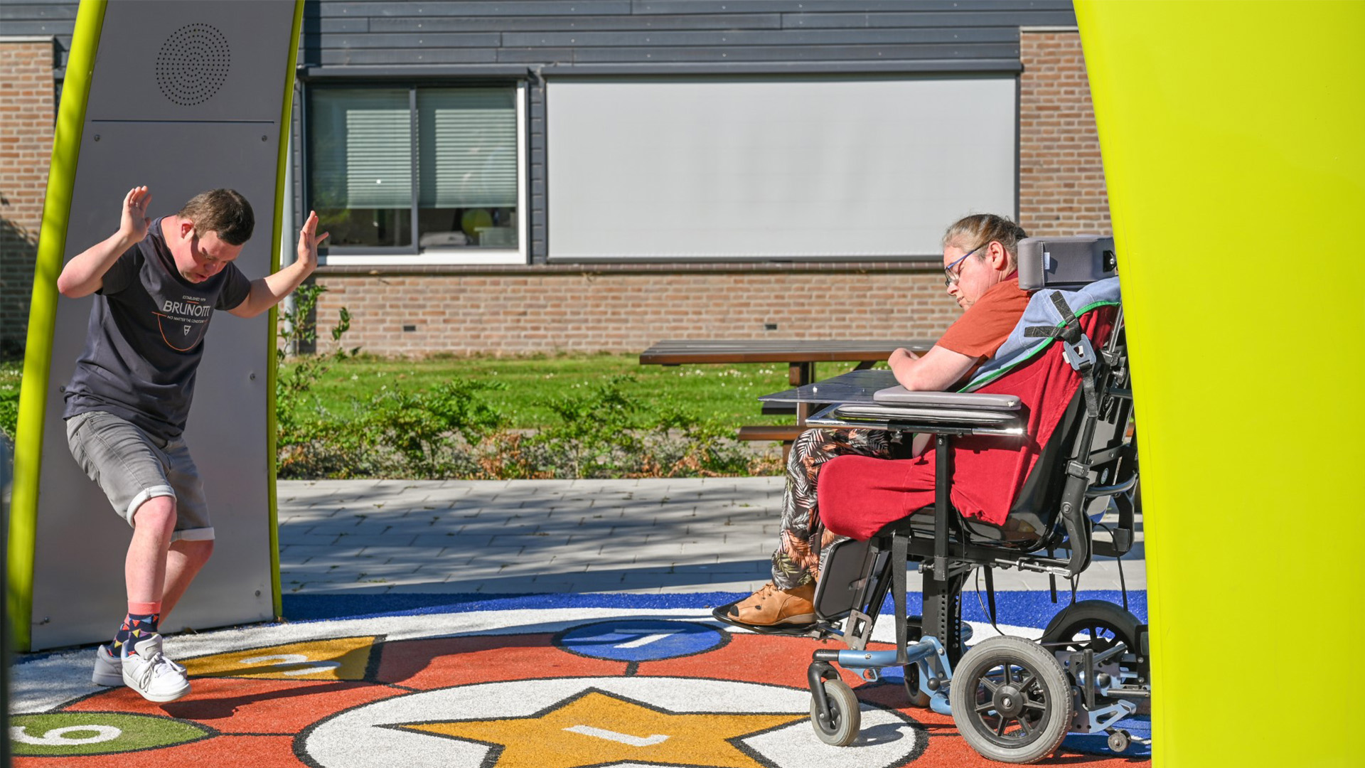 Resident from Ipse de Bruggen playing together under the Lappset Sona Interactive dance and play arch