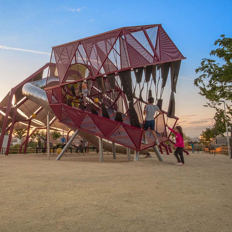 Niños jugando en un parque infantil con dinosaurios