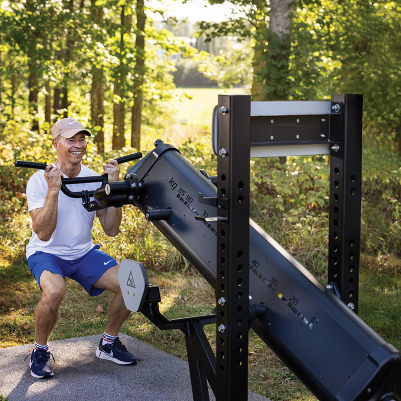 En man styrkeränar på en Sisu i en park