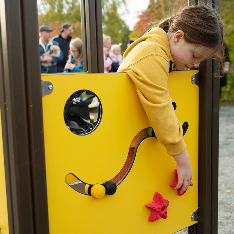 Flicka leker med lekpanel i Fjärilsparken i Kårsta