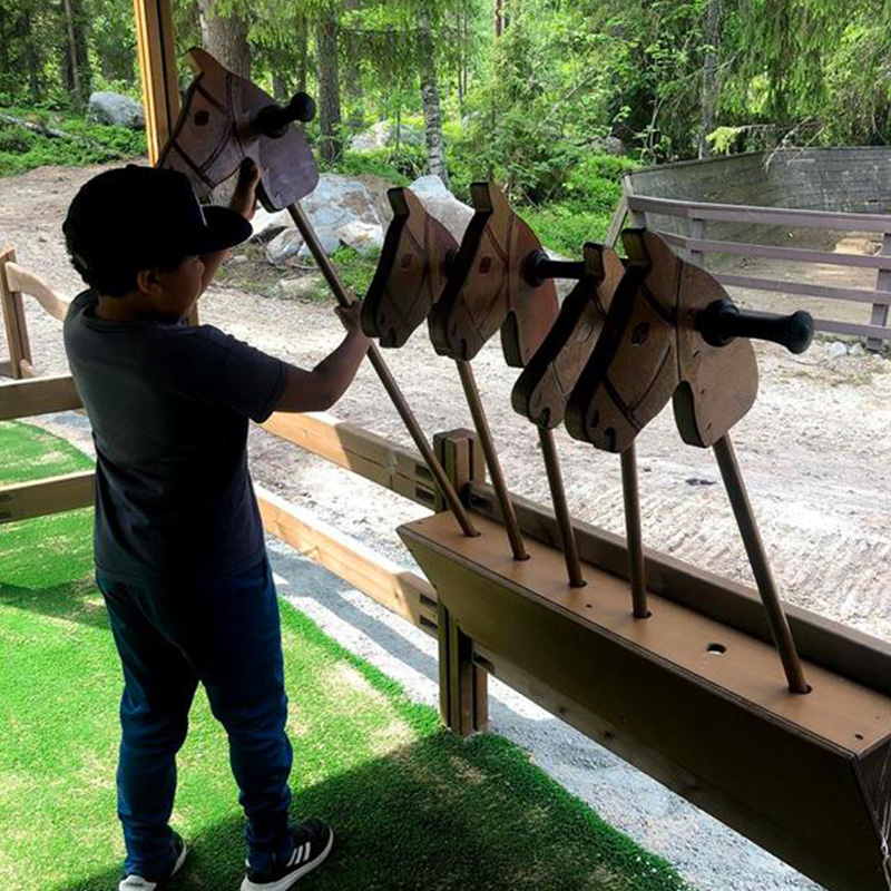 Child plays with wooden horses at Ranua zoo in Finland. Photo: Eerika Saravuoma and Kirsi Saravuoma