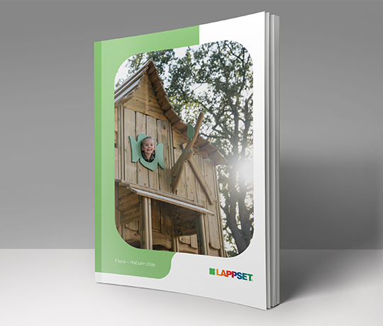Image of a brochure or magazine placed upright against a plain background. The cover shows a child peeking through a wooden playhouse window with trees in the background. The text on the cover reads "Flora - Nature play" and includes the Lappset logo.