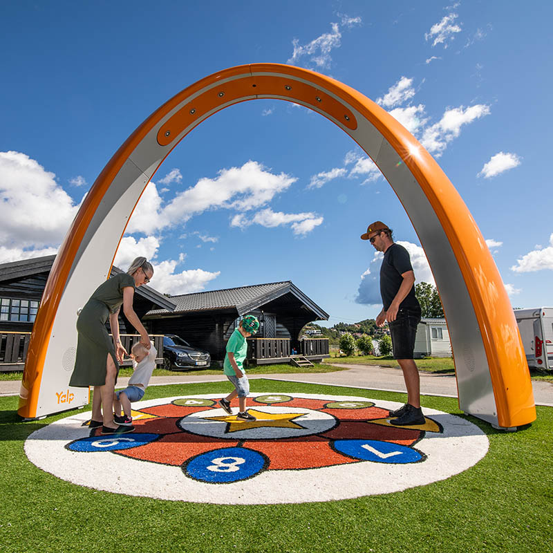 En familie, der spiller på en Sona Interactive Dance and Play Arch på en campingplads i Norge.