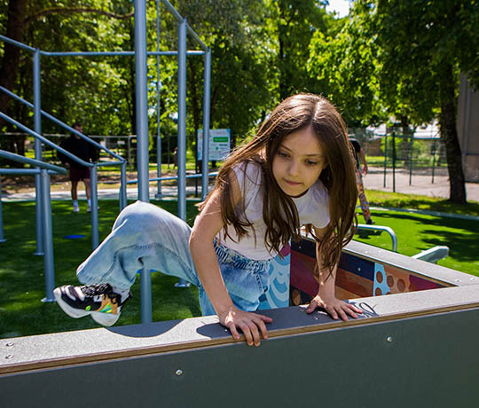 Girl climbing over an obstacle