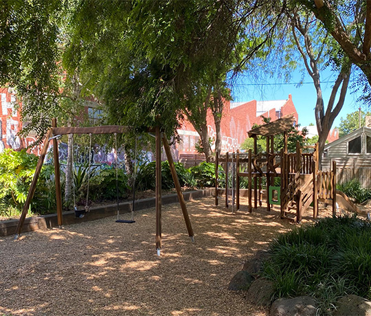 A small nature play playground next to a street in Australia.