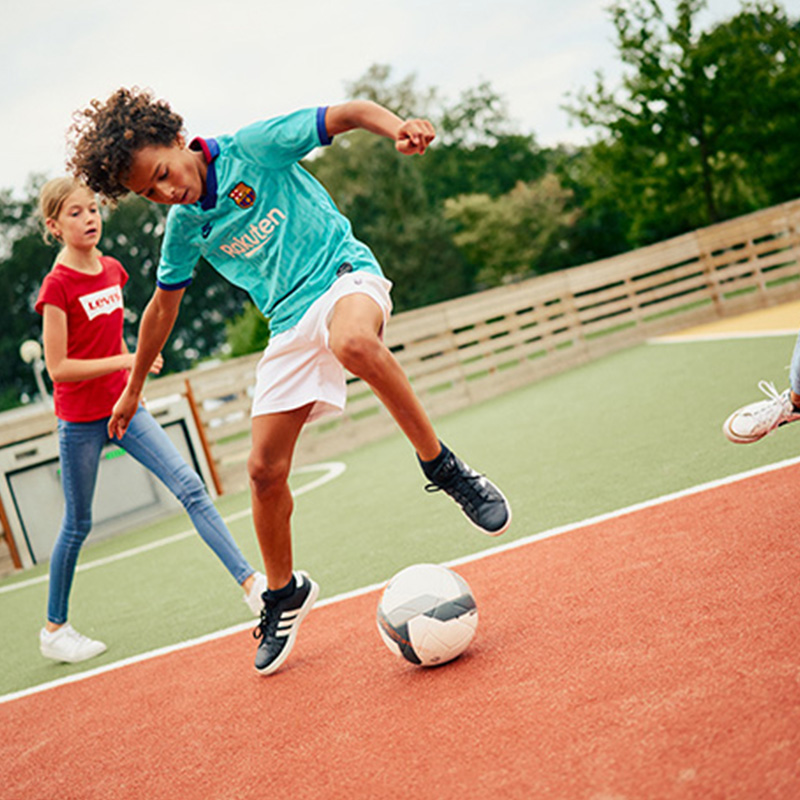 Children playing football in the Toro Interactive sports arena