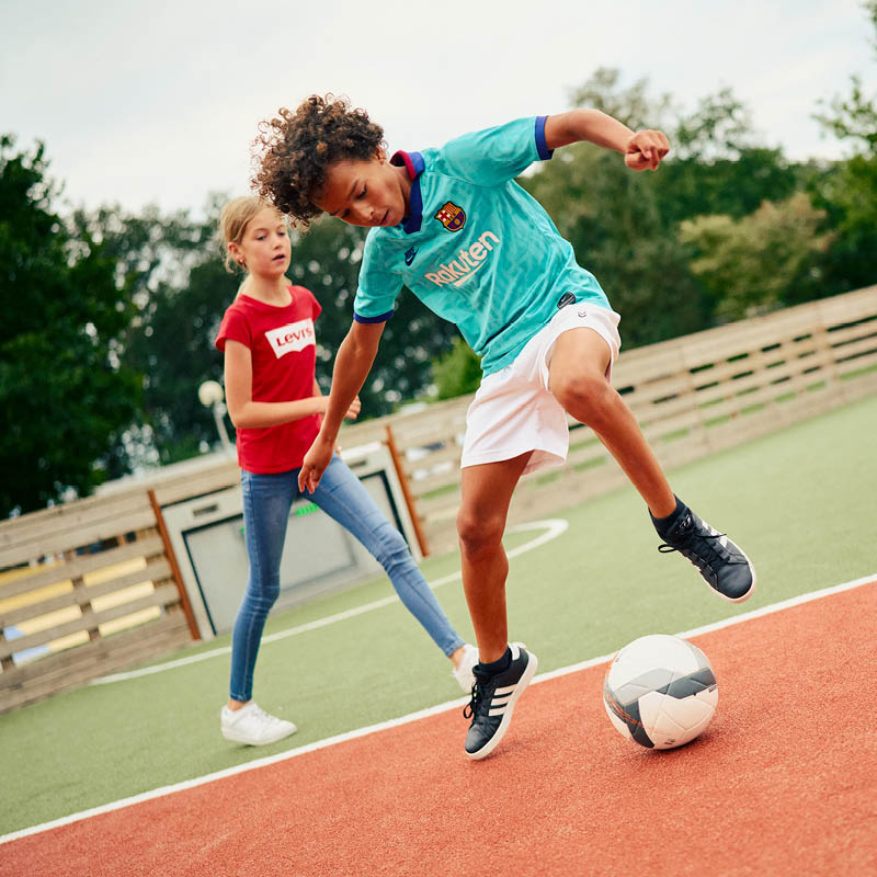 Barn spelar fotboll i en Toro idrottsarena