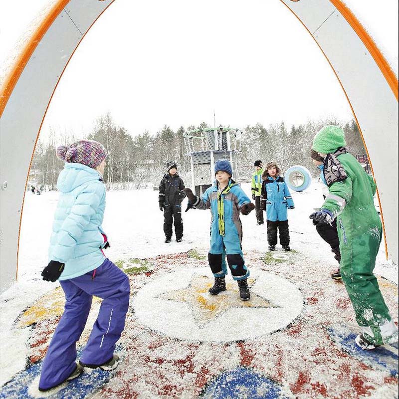 Niños jugando en la nieve bajo el arco Sona