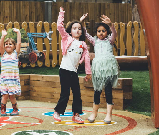 Girls playing with Sona on the Peter Rabbit-themed playground in the UK