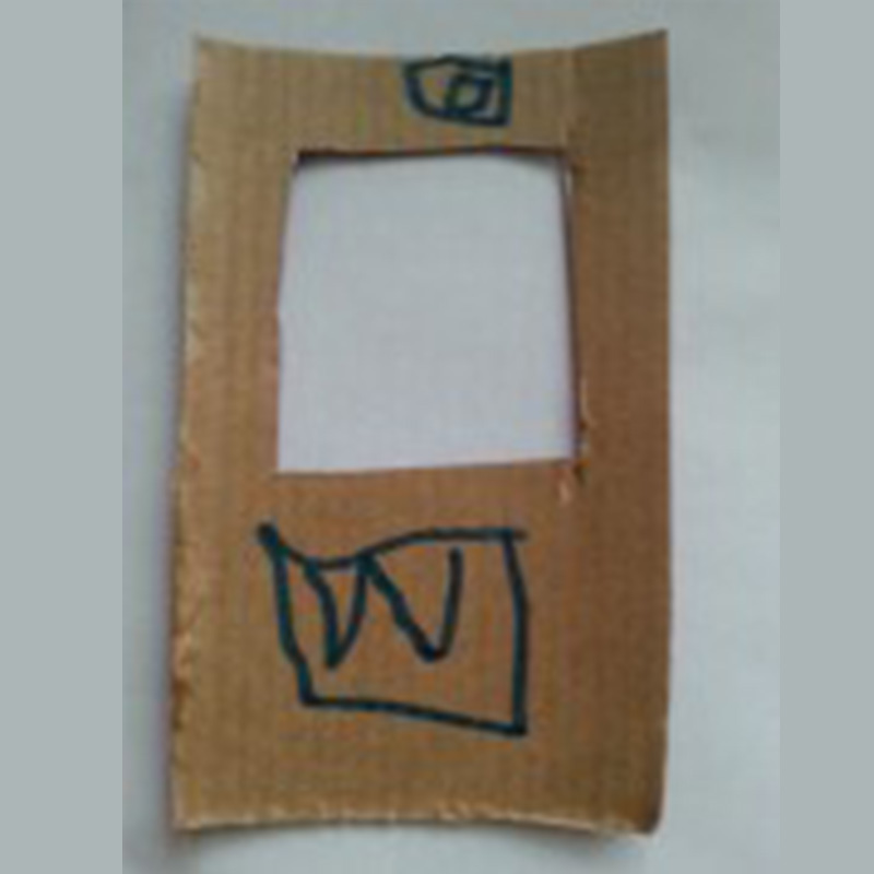 A piece of brown cardboard with a large rectangular cutout in the middle and two smaller squares drawn on it: one near the top and the other near the bottom, both outlined with a blue marker.