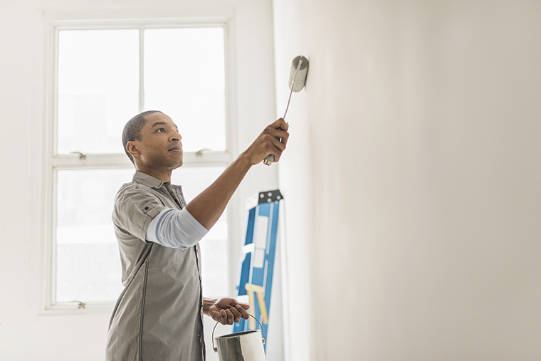 A professional painter giving a home a fresh coat of a neutral paint color