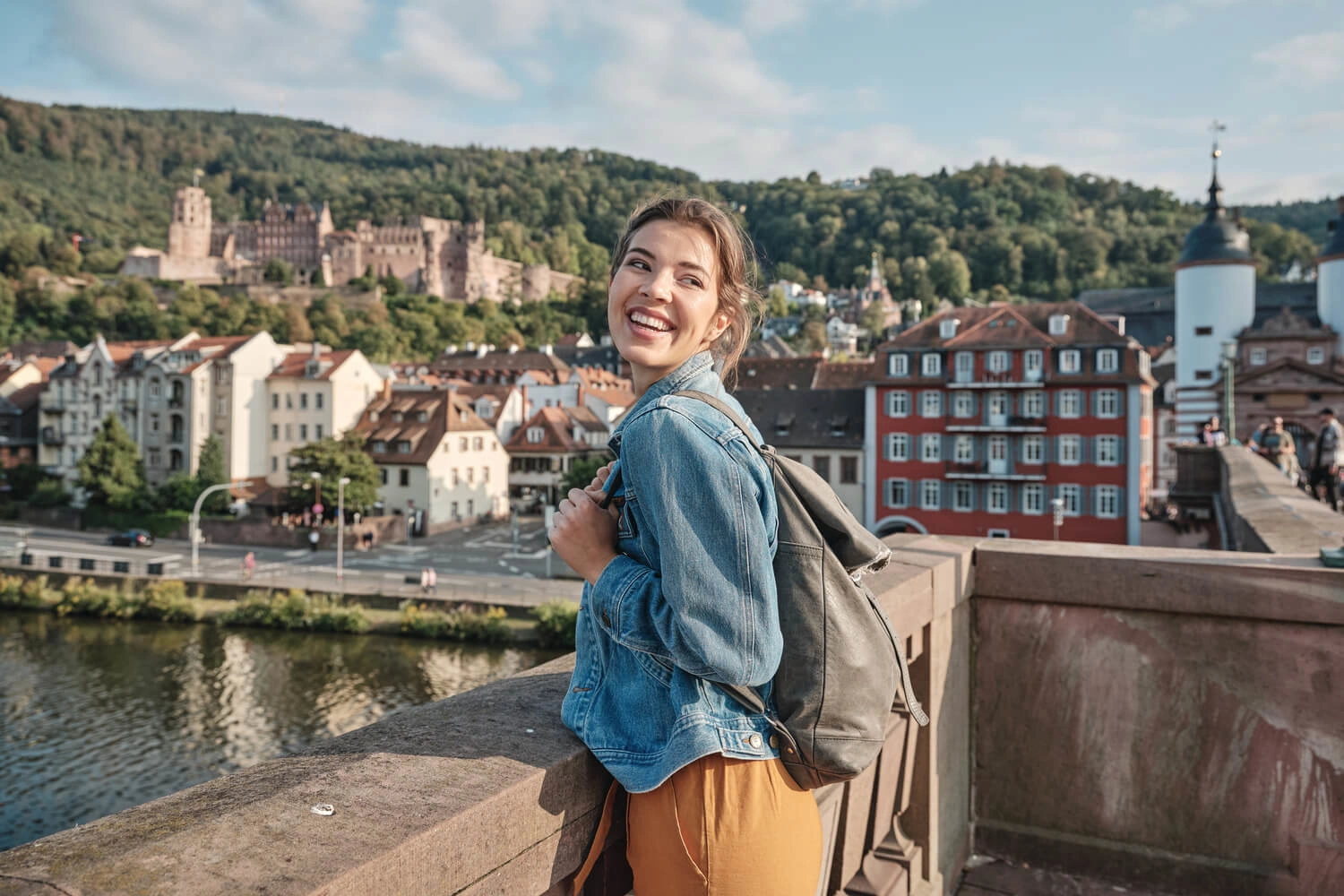 Frau auf der Alten Brücke in Heidelberg. Sie lacht in die Kamera.