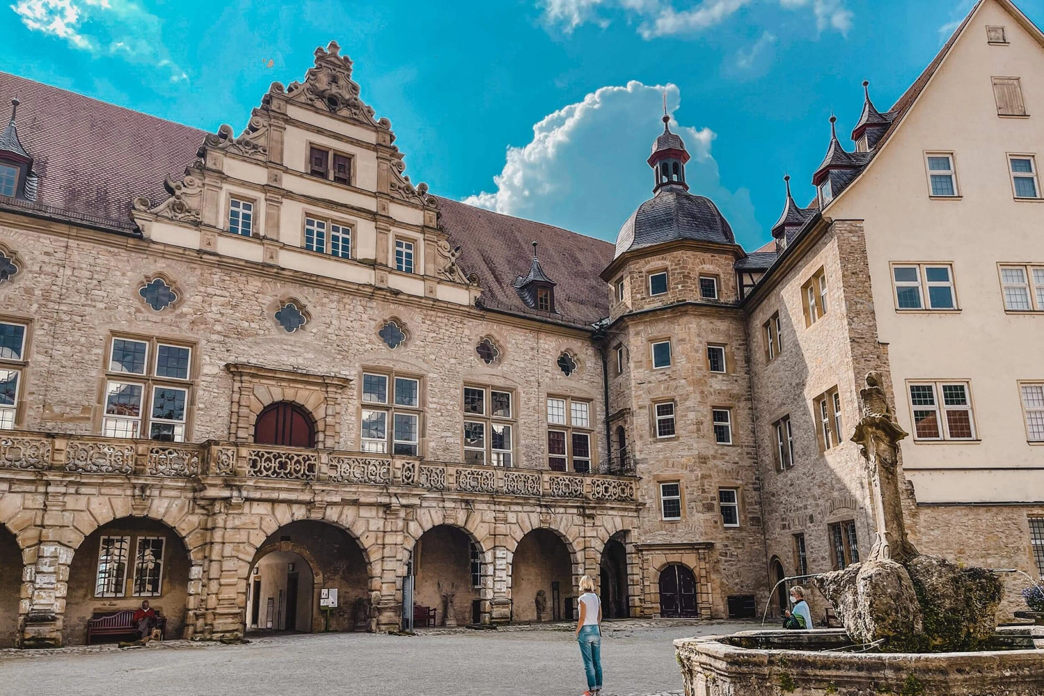 Eine Frau steht im Innenhof eines Schlosses