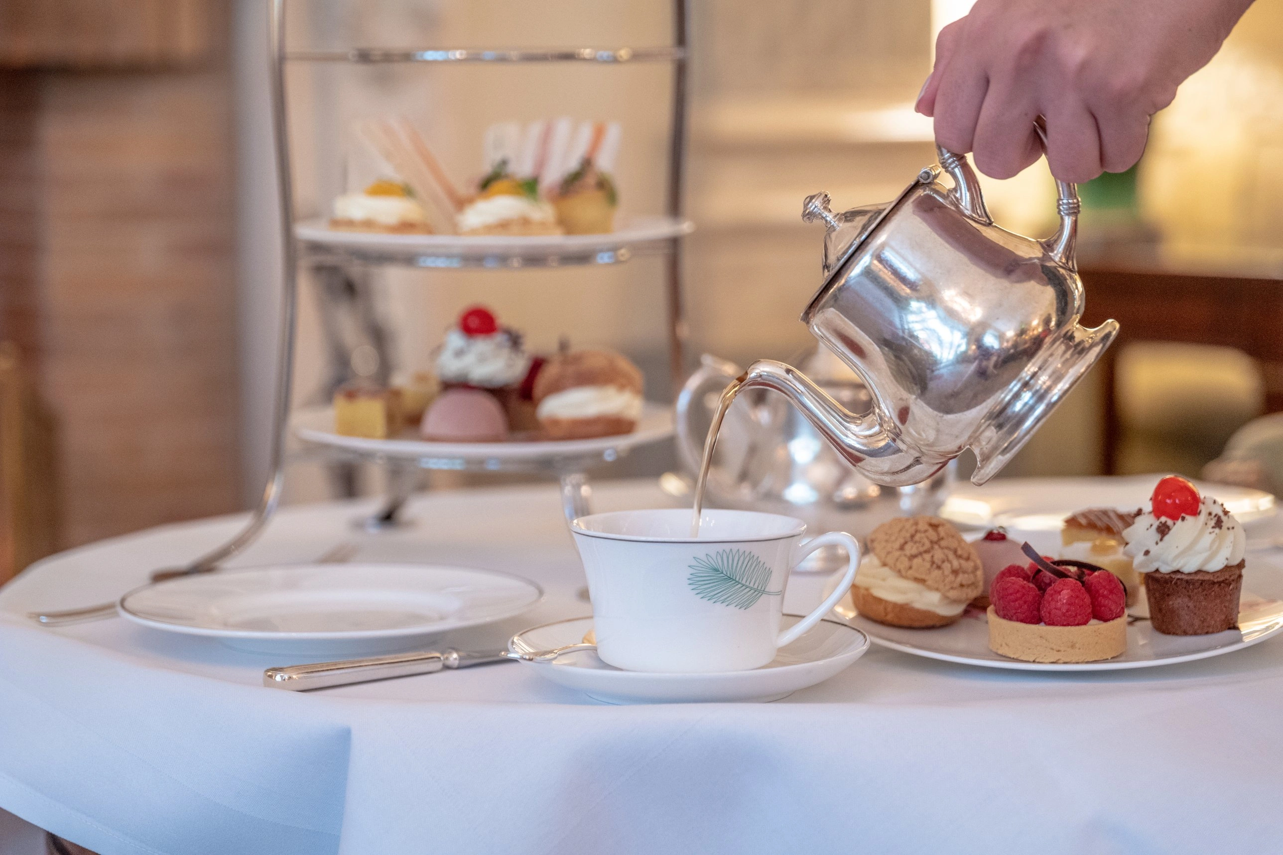 Afternoon Tea mit feinen süßen und herzhaften Köstlichkeiten sowie aromatischem Tee in der Kaminhalle des Brenners Park-Hotel & Spa in Baden-Baden