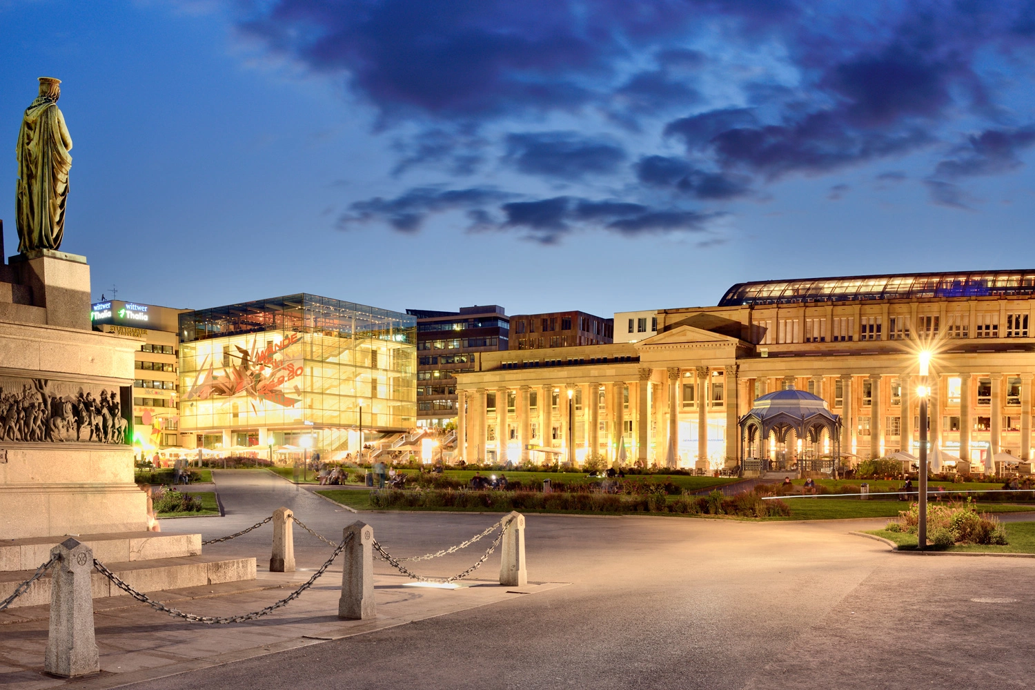 Abendstimmung am Stuttgarter Schlossplatz mit beleuchtetem Königsbau und modernem Kunstmuseum.
