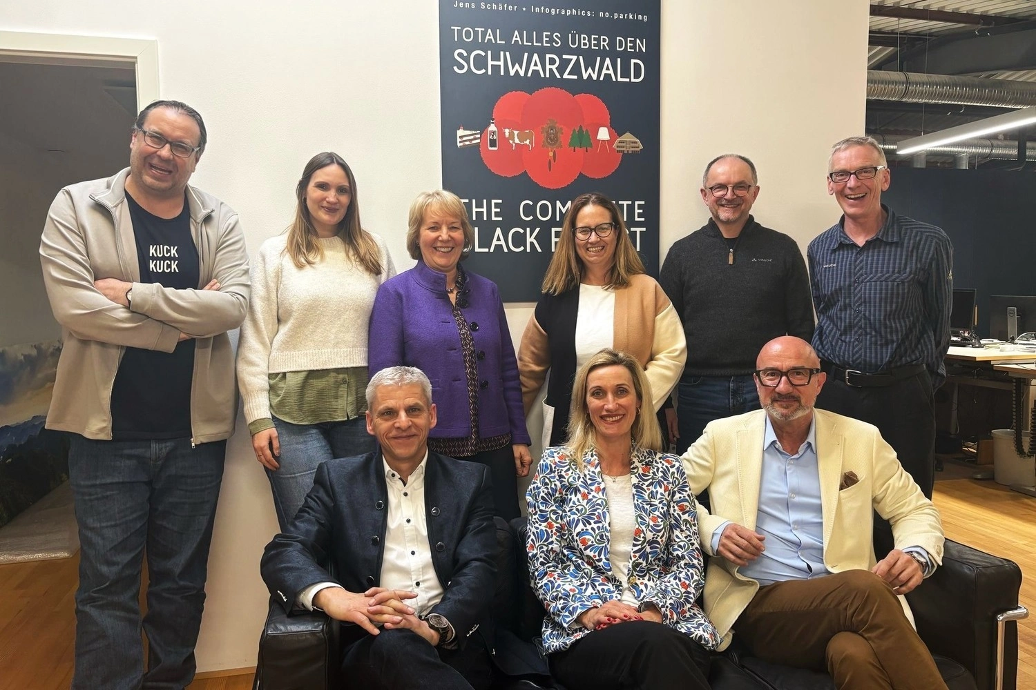 Gruppenbild einer Gruppe von neun Personen in einem geschäftlichen Kontext