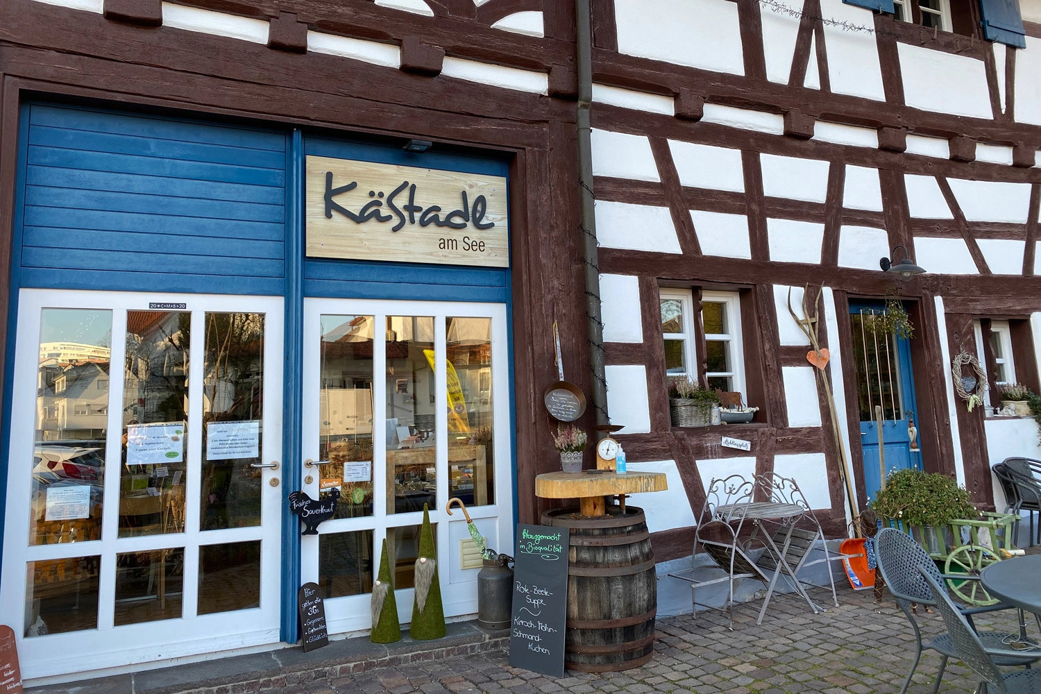 Nahaufnahme eines Fachwerkhauses in dem ein Käsegeschäft untergebracht ist.