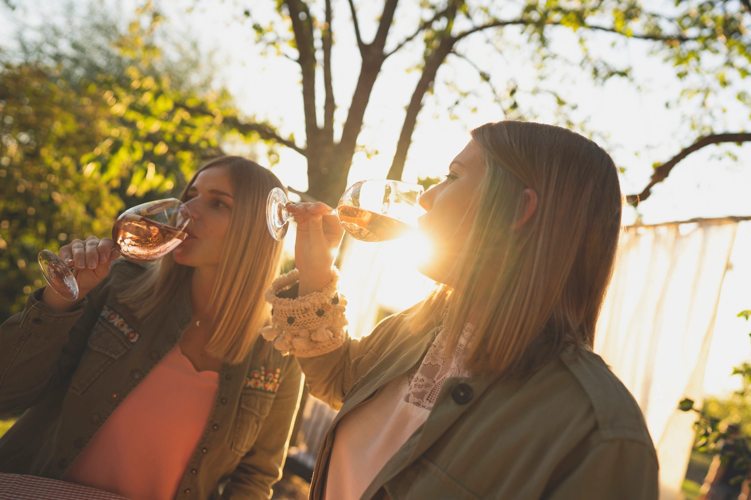  Two young women enjoy a glass of wine in the evening sun.