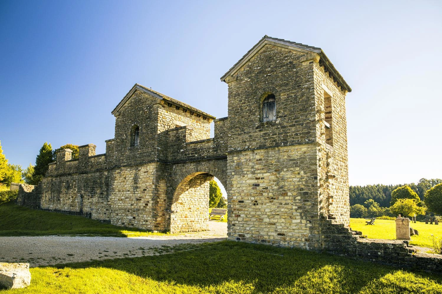 Ein imposantes römisches Kastell steht auf einer grünen Wiese.