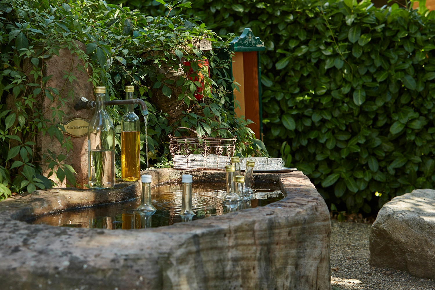  There are several bottles of schnapps in a fountain.