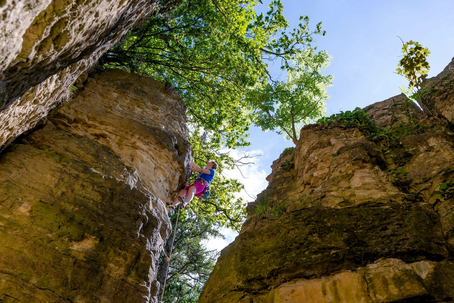 Eine Kletterin klettert an einem steilen Felsen.
