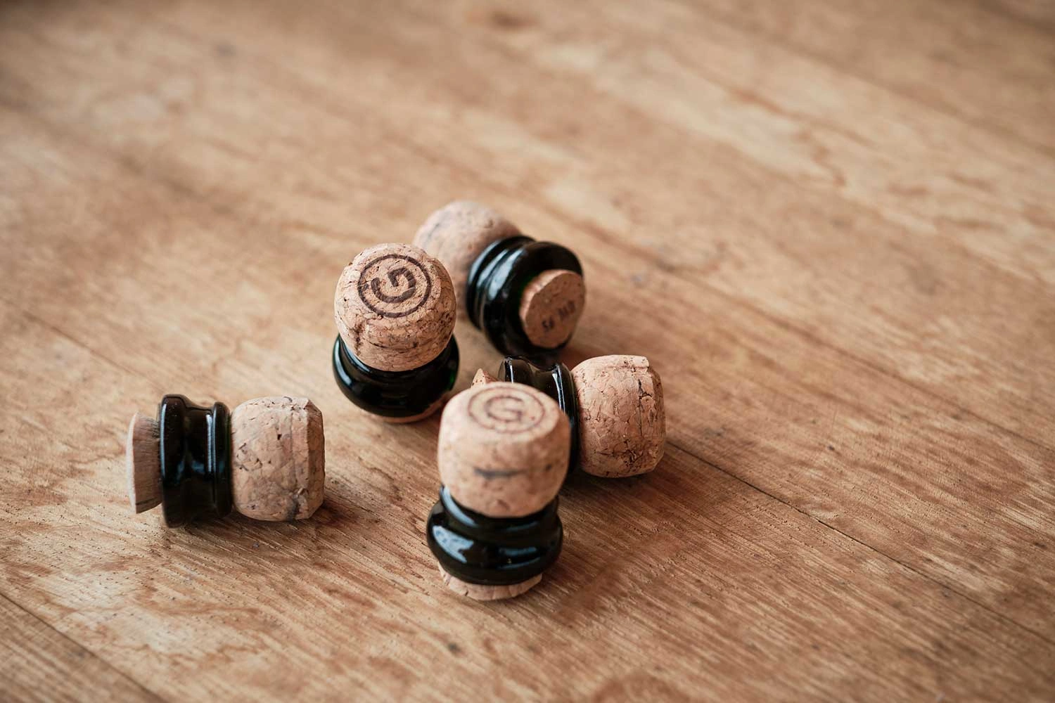A few wine corks lie on a wooden table.