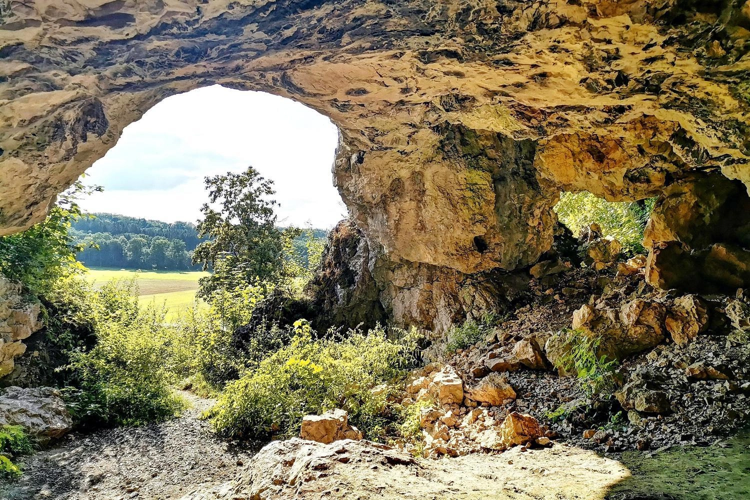 Höhle, von deren Eingang viel Licht hereinfällt.