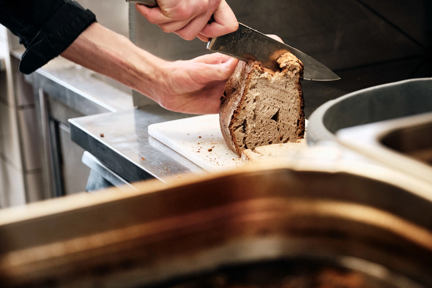 Ein Holzofenbrot wird angeschnitten.