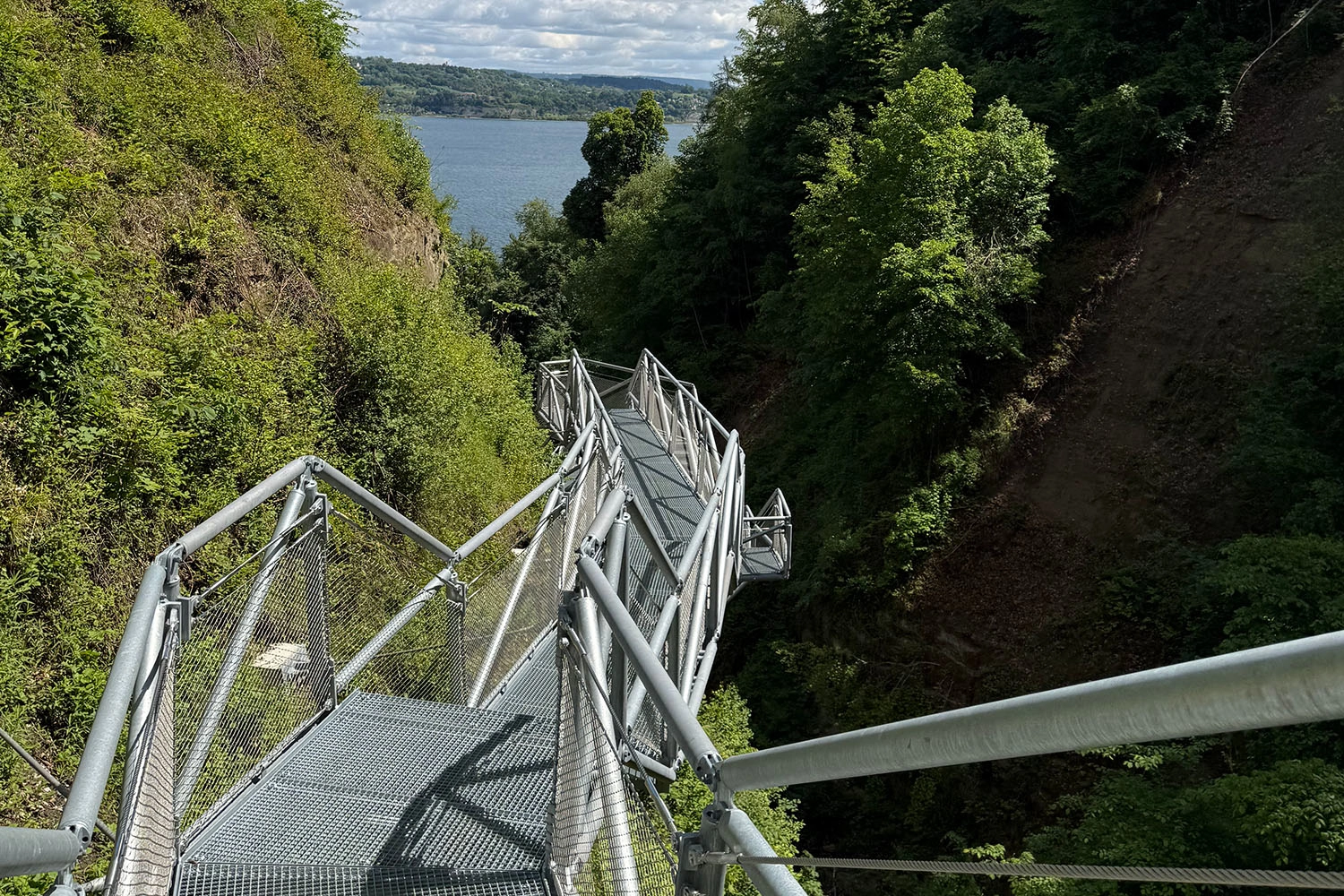 Aussichtsplattform und Steg über einer bewaldeten Schlucht mit Blick auf den Bodensee; informiert über Wanderweg und Naturerlebnis nahe Meersburg.