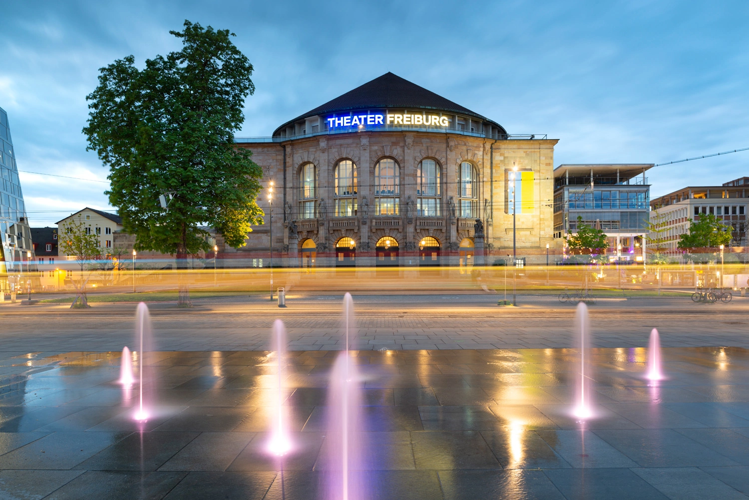 Blick auf die beleuchtete Fassade eines prächtigen Gebäudes bei Dämmerung