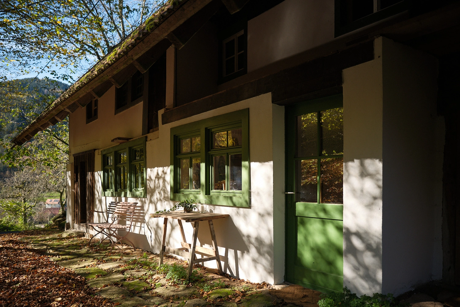 Ein altes Bauernhofsgebäude umgeben von Bäumen