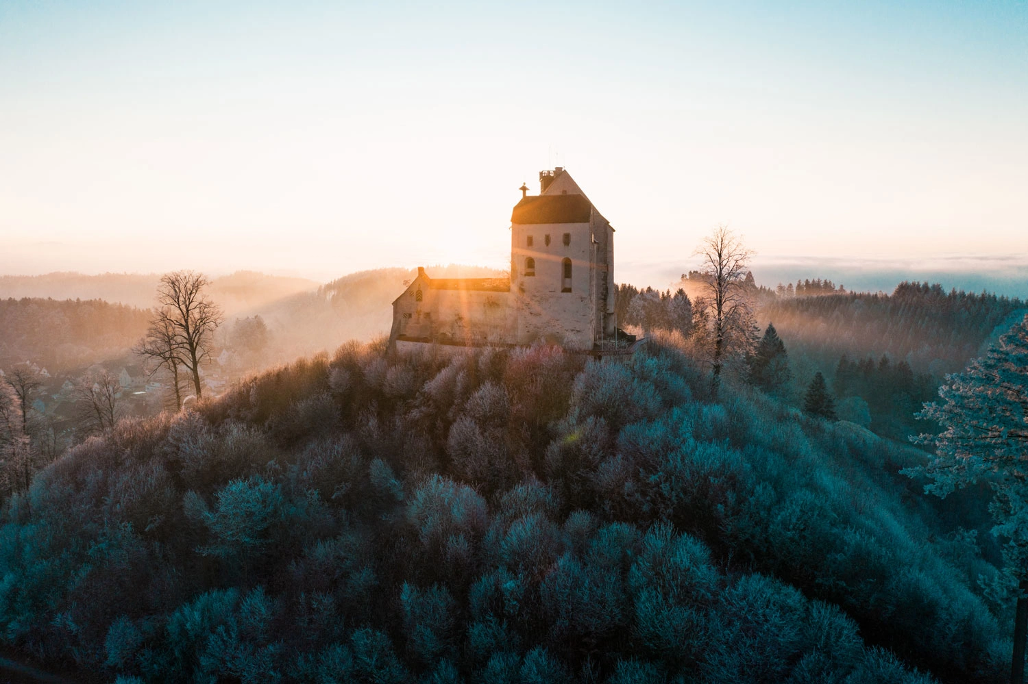 Drone shot of Waldburg Castle in late fall as the sun rises 