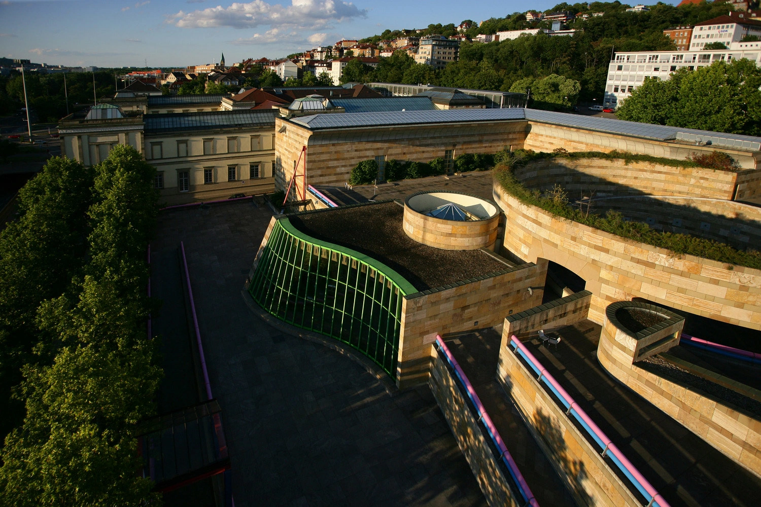 Exterior view of the Staatsgalerie in Stuttgart in the sunshine. The built-up slopes of Stuttgart can be seen in the background.