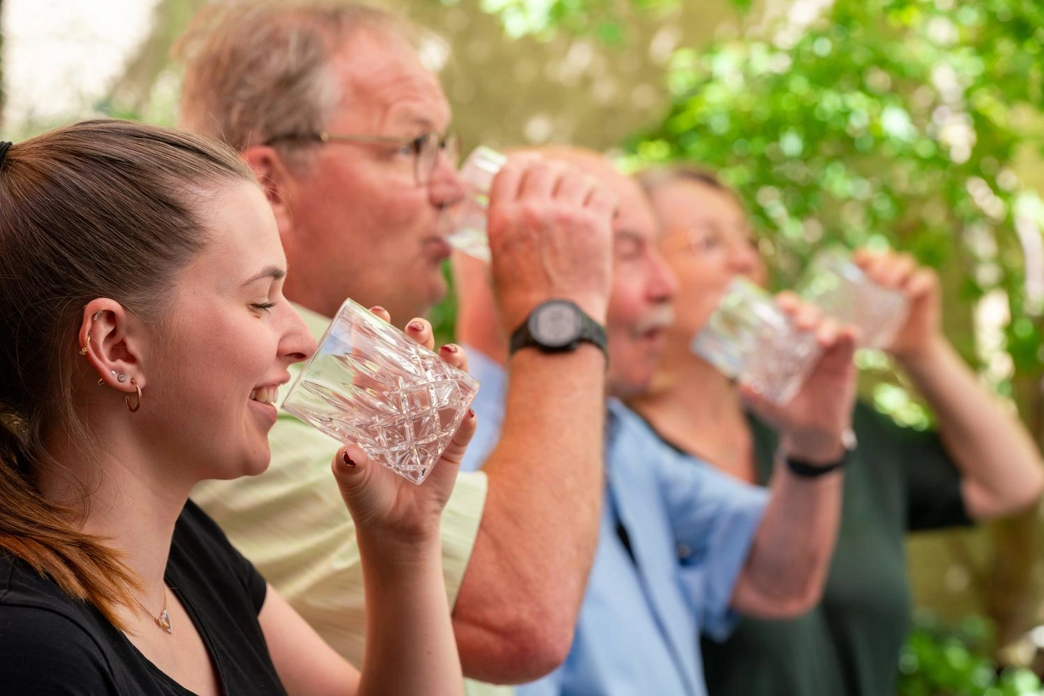 Personen testen Mineralwasser auf Gläsern.