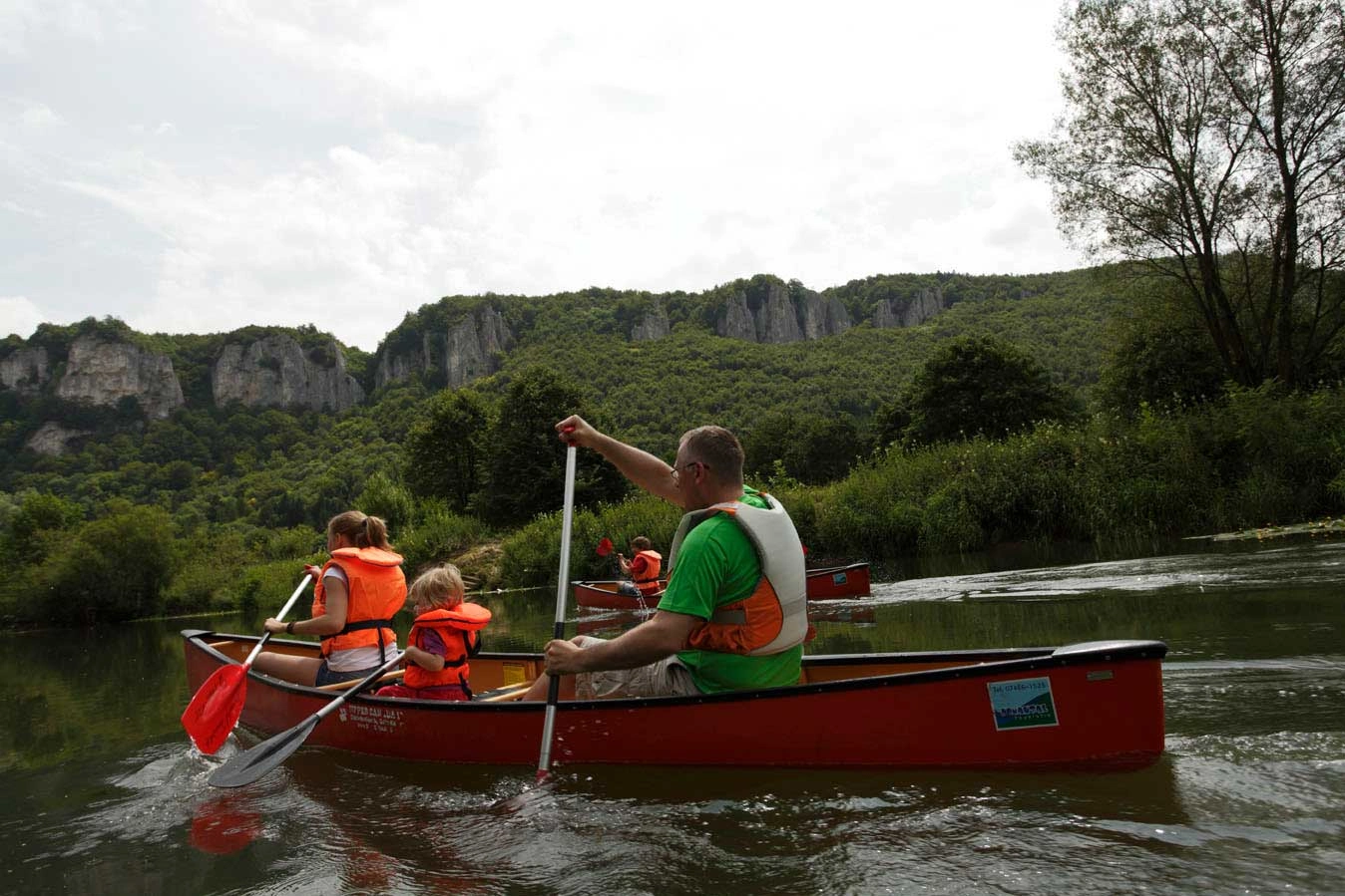 Auf einem Fluss macht eine Familie gerade eine Kanutour.