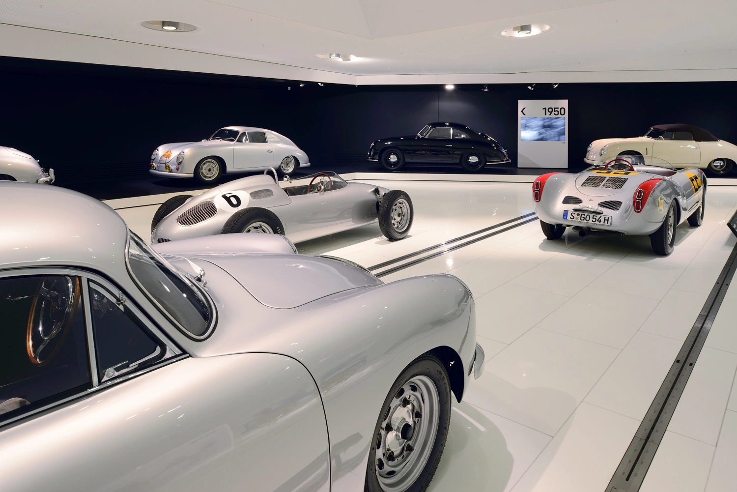 Verschiedene Porsche-Modelle stehen auf einer Ausstellungsfläche