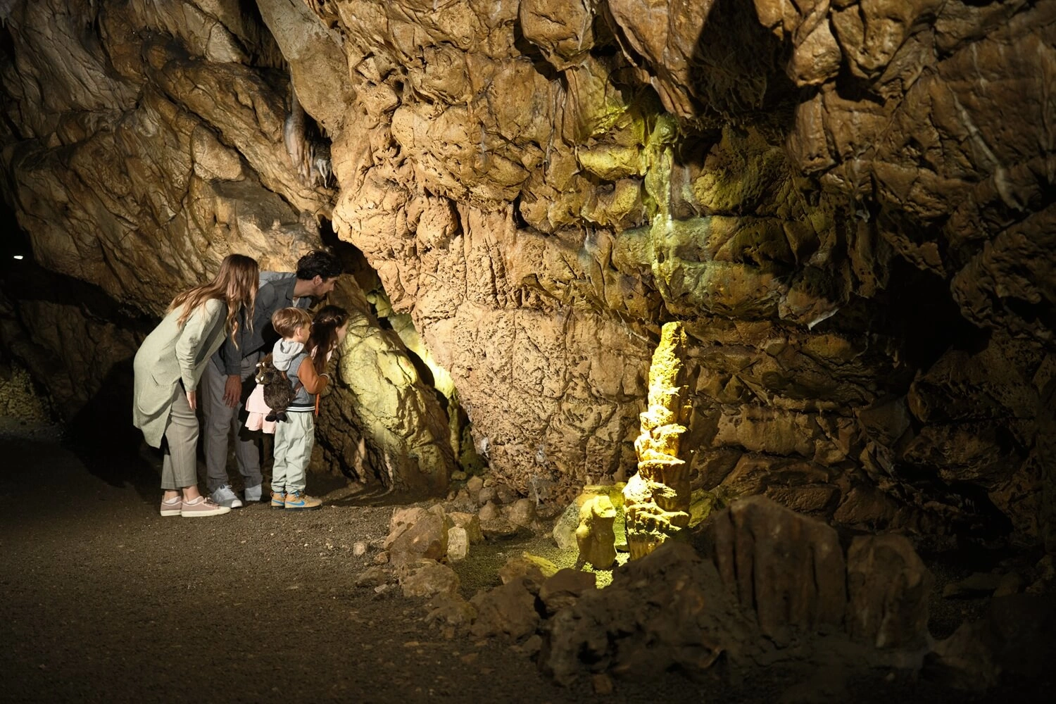 Eine Familie schaut sich in einer Höhle um.