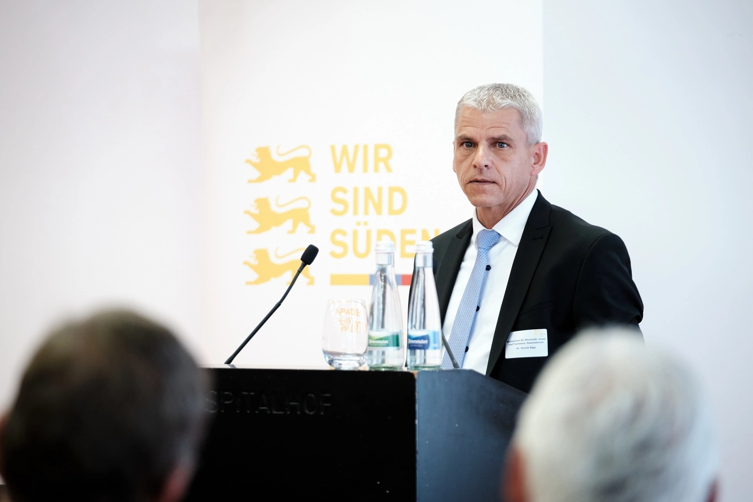 Ein Mann im Anzug steht an einem Rednerpult.