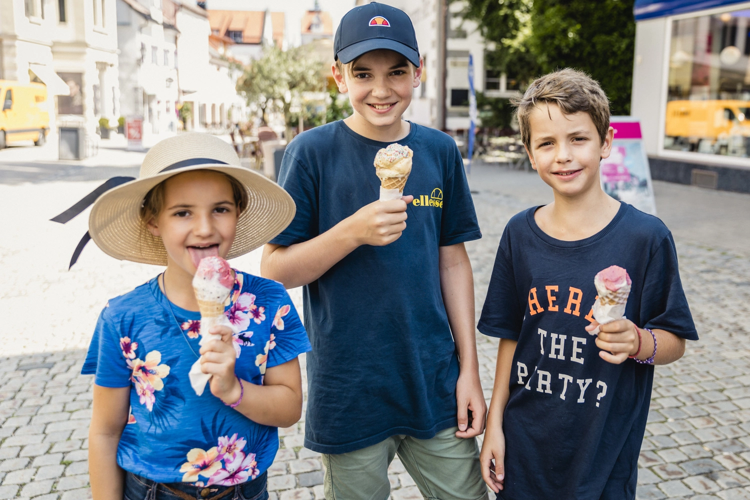 Zwei Jungs und ein Mädchen essen ein Eis.