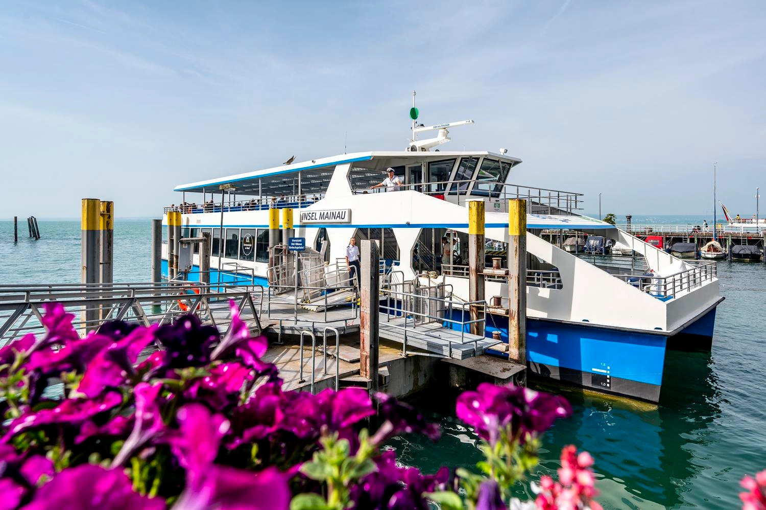 Ein Elektroschiff auf dem Bodensee liegt am Steg in der Sonne.