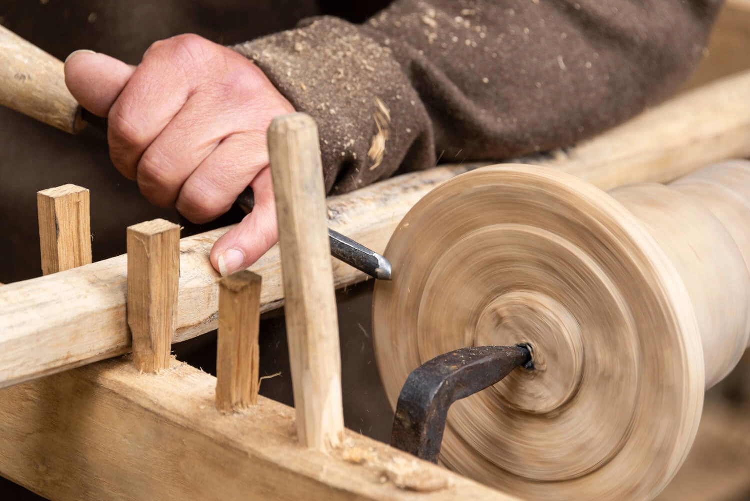 A person works with wood on a turntable.