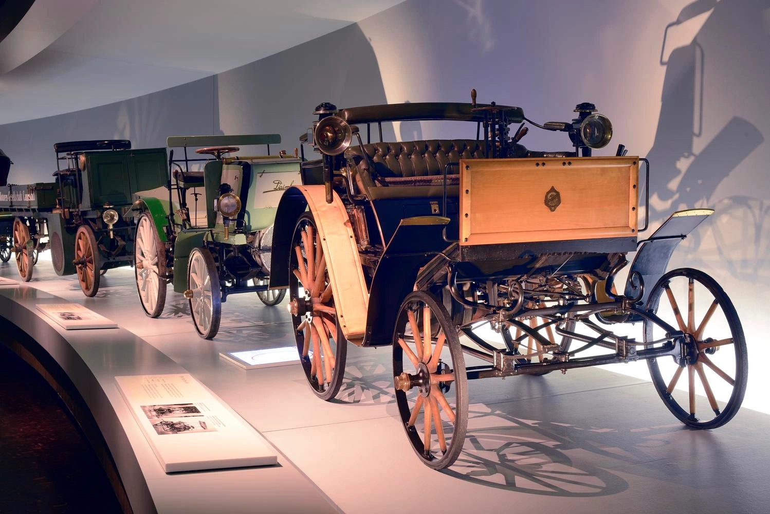 A series of old car models on display in the Mercedes-Benz Museum.