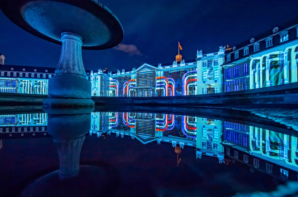 Illuminationen werden bei Dunkelheit an die Fassade eines Schlosses projiziert.