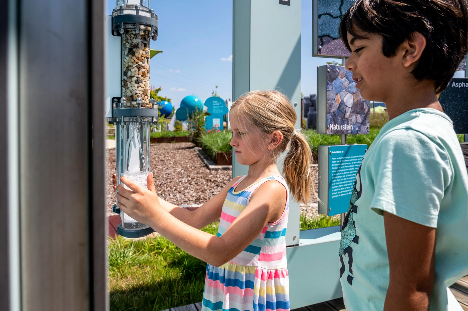 Two children stand at a station of an interactive exhibition.